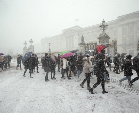Tourists look at Buckingham Palace In The Snow