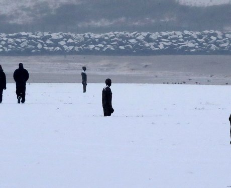 Walkers in the snow by Another Place by Anthony Go